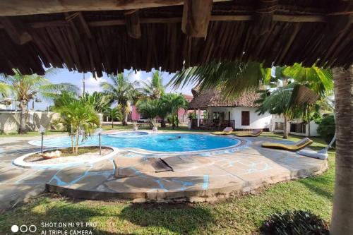 a swimming pool in a yard with a resort at Dadida‘s Pool Cottage in Diani Beach