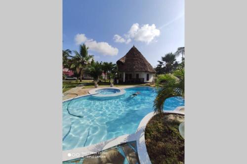 a view of a swimming pool at a resort at Dadida‘s Pool Cottage in Diani Beach