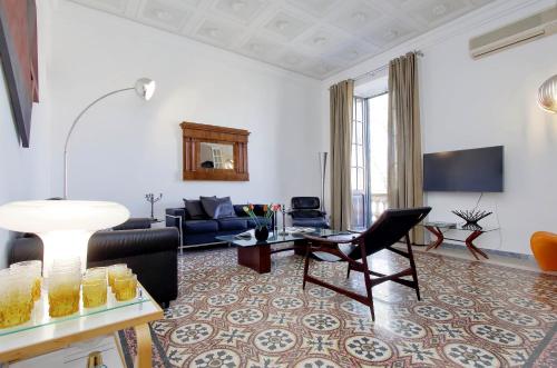 4BNB - Tiberina Spacious Apartment في روما: غرفة معيشة مع أريكة وطاولة