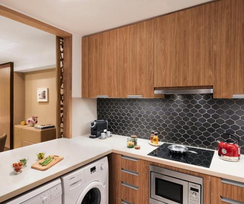a kitchen with a washer and dryer at Taj Wellington Mews Chennai in Chennai
