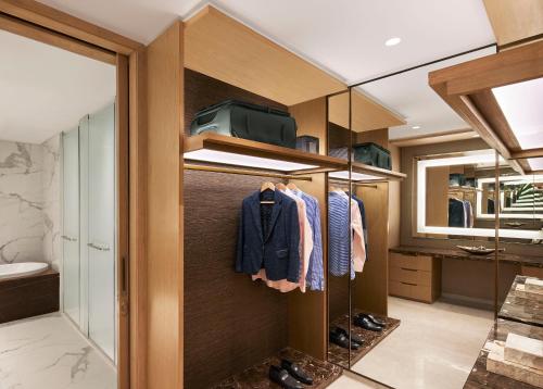 a bathroom with a walk in closet with clothes at Taj Wellington Mews Chennai in Chennai