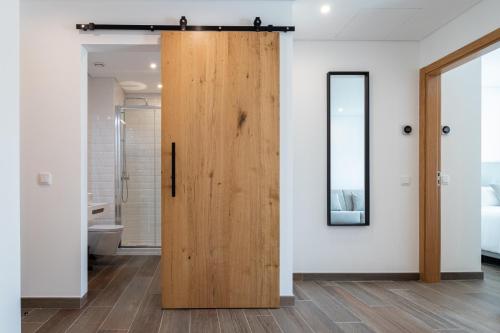 una puerta de madera en un baño con aseo en Roots Hotel en Faro
