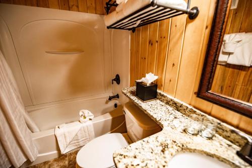 a bathroom with a sink, toilet and bathtub at Elk Country Inn in Jackson