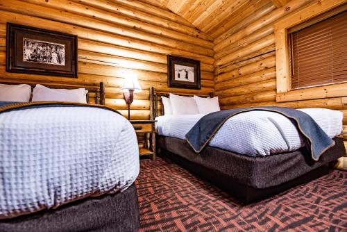 1 dormitorio con 2 camas en una cabaña de madera en Elk Country Inn, en Jackson