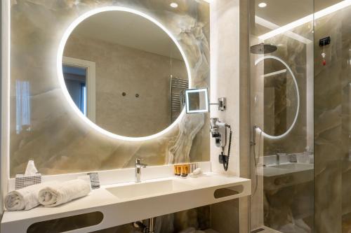 bagno con lavandino e specchio di Aemilia Hotel Bologna a Bologna