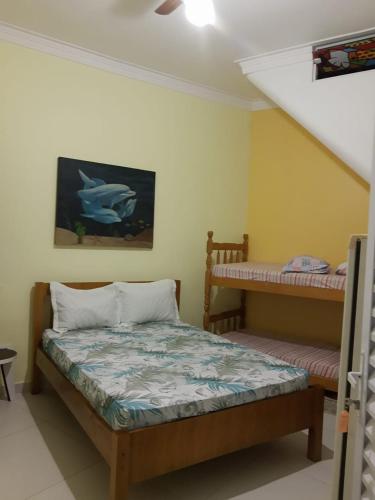 a bedroom with a bed and a bunk bed at Pousada Enseada de Bertioga in Bertioga