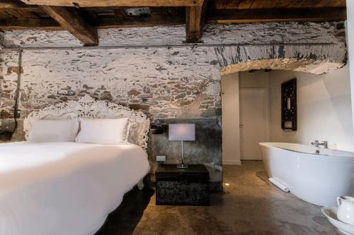 a bedroom with a bed and a bath tub at ANRÁN at Tidwell Farm in Staverton