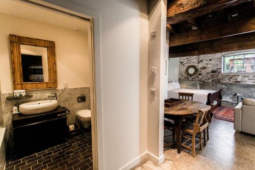 a kitchen and dining room with a table and a bathroom at ANRÁN at Tidwell Farm in Staverton