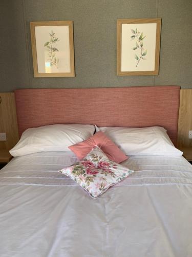 un letto bianco con due cuscini sopra di The Rawcliffe a Dunoon