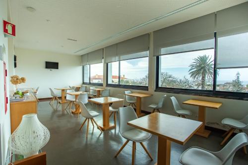 a large room with tables and chairs and a large window at Thomas Place in Ponta Delgada
