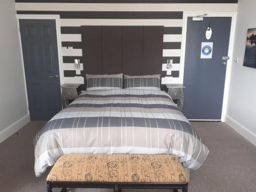 ローストフトにあるSouth Beach B & Bのベッドルーム1室(大型ベッド1台、木製ヘッドボード付)