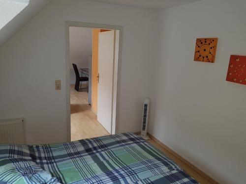 um quarto com uma cama e uma porta que leva a um corredor em Iris 2-3 Personen - Ferienwohnungen Wagner & Gaul Falkenauel em Falkenauel