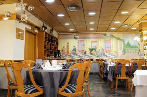 a dining room with tables and chairs and a painting at Yomo Eureka in Andorra la Vella