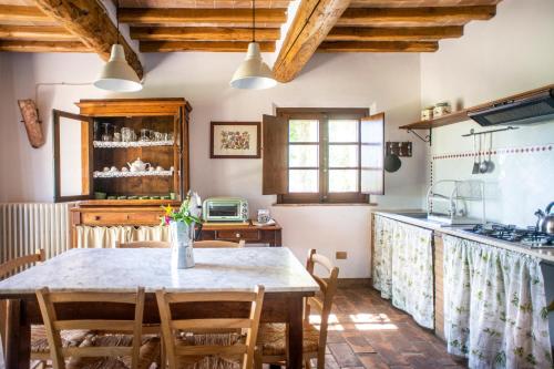 a kitchen with a table and chairs in a room at Agriturismo Pieve Sprenna in Buonconvento