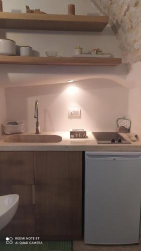 a kitchen with a sink and a stove at La Volta del Conte-Holiday Home Centro Storico in Cisternino