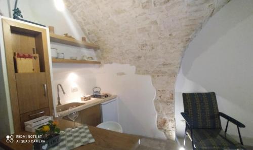 een keuken met een tafel en een stoel in een kamer bij La Volta del Conte-Holiday Home Centro Storico in Cisternino