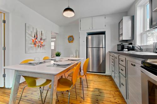 cocina con mesa blanca y sillas amarillas en Les Appartements du 790, en Quebec