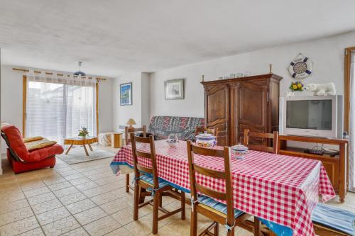 un salon avec une table et une télévision dans l'établissement Charmante Maison en Campagne près de Nevez avec Jardin Clôturé, à Névez