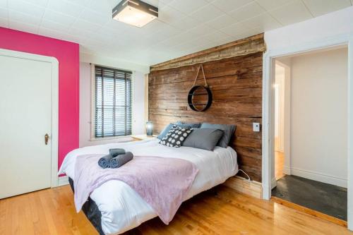 um quarto com uma cama grande e uma parede de madeira em L'Auberge Sainte-Anne - ski, spa et basilique em Sainte-Anne-de-Beaupré