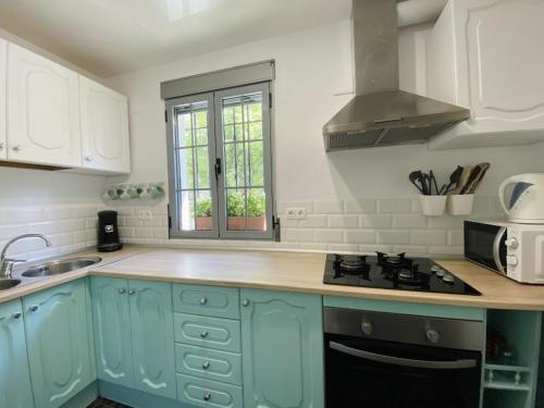 a kitchen with blue cabinets and a stove top oven at Casa RIVER VIEW - Cazorla in Cazorla