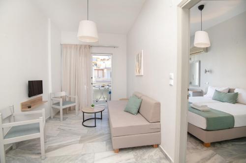 a bedroom with a bed and a couch and a table at Mardinik Hotel Apartments in Rethymno