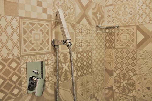 y baño con ducha y pared de azulejos. en Zibibbo Beach Apartments - Trapani, en Trapani