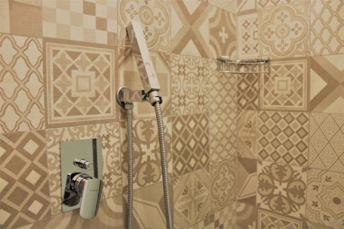 a shower in a bathroom with a tile wall at Zibibbo Beach Apartments - Trapani in Trapani