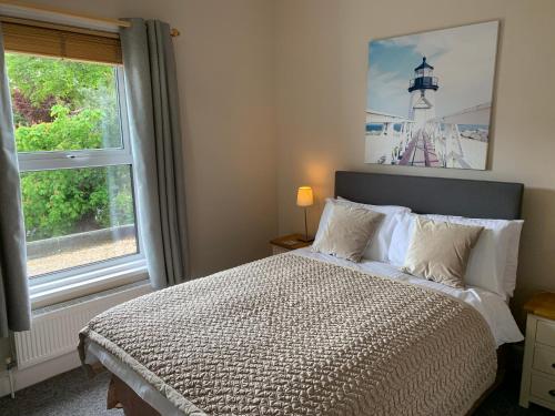 a bedroom with a bed and a window with a lighthouse at The Chestnuts in Shanklin