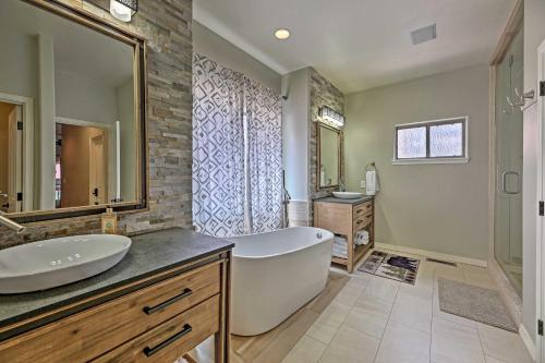 a bathroom with a tub and a sink and a mirror at Near Woodland Lake Park Cabin with Serene Deck! in Pinetop-Lakeside