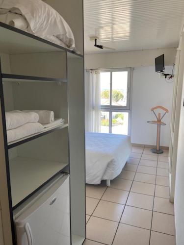 a room with a bedroom with a bed and a window at Hotel Bord A Bord in Noirmoutier-en-l'lle