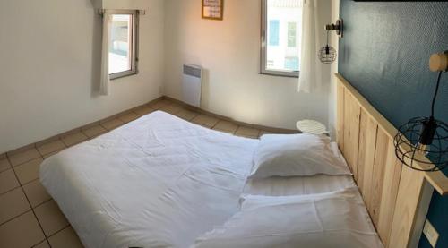 a large white bed in a room at Hotel Bord A Bord in Noirmoutier-en-l'lle