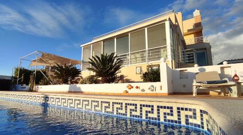 uma casa com piscina em frente a uma casa em Villa Miradouro by Be Cherish em Silves