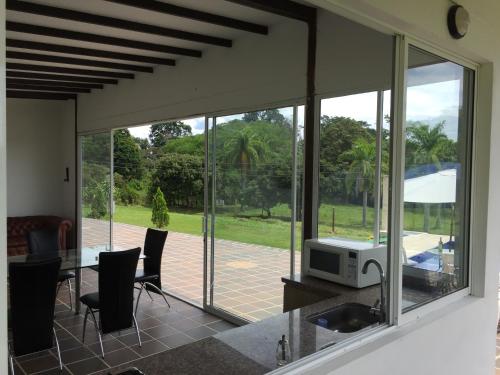 a kitchen with glass doors and a table with a microwave at Finca La Ranchera No. 2 in Tarso
