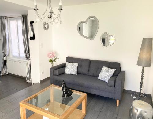 ein Wohnzimmer mit einer Couch und einem Glastisch in der Unterkunft Villa la Vie, Maison entière pour 4 personnes, avec extérieur, Tout inclus, ménage, linge, wifi in Dieppe