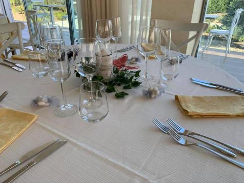 a white table with wine glasses and flowers on it at Agriturismo Tenuta Don Giovanni in Melendugno