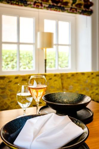 a table with two plates and glasses of wine at Hotel Stadt Hamburg in Westerland (Sylt)