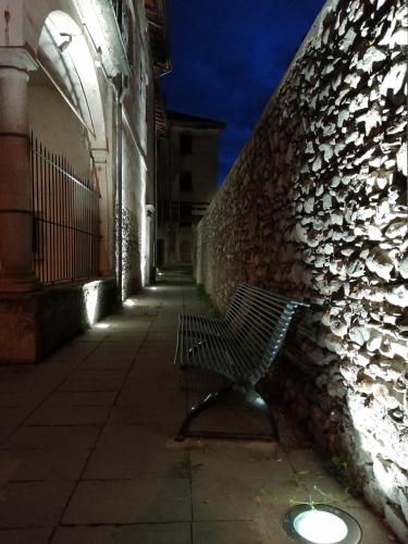 a bench sitting next to a stone wall at Le3stanze in Borgomanero