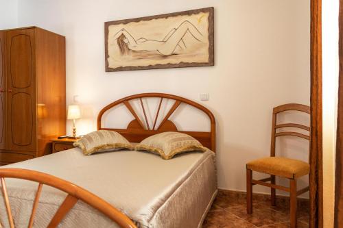 a bedroom with a bed and a painting on the wall at Moradia Borda D'Água in Nazaré