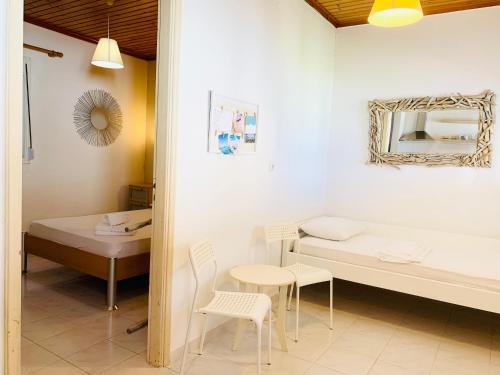 Habitación con cama, mesa y sillas. en Seaside Bungalows Petalidi, en Petalidi