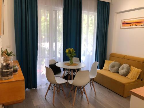 een woonkamer met een tafel en stoelen en een bank bij Marina Apartments and Jet Ski in Augustów