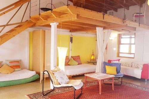 una camera con due letti, un divano e un tavolo di Alegría Aire - Eco Retreat Finca Artis Tirma a Tarajalejo