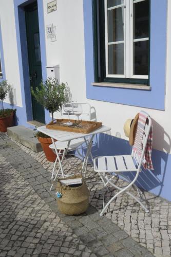 a table and chairs sitting outside of a building at Casa do Largo in Alcácer do Sal