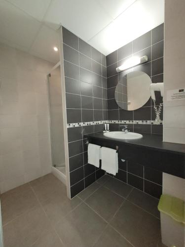 a bathroom with a sink and a mirror at La Croix Blanche in Beaurepaire-en-Bresse