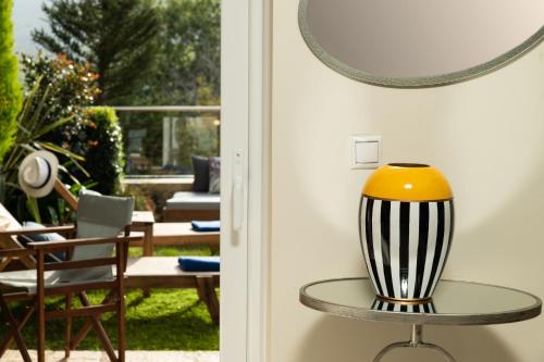 a table with a yellow and black vase on it at Villa Cressida in Kávallos