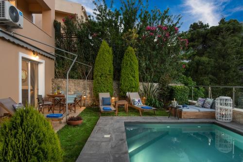 um quintal com uma piscina, uma mesa e cadeiras em Villa Cressida em Kávallos