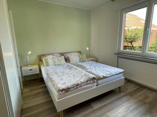 a small bedroom with a bed and a window at Haus Kormoran Borkum in Borkum