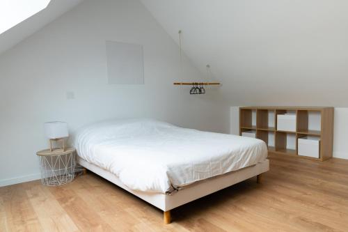 1 dormitorio con cama blanca y suelo de madera en Joli loft spacieux de 100m2 pour 10pers en Saumur