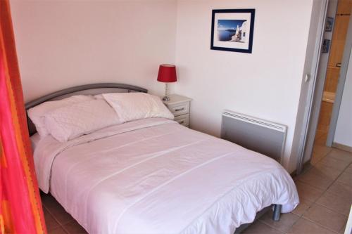 une petite chambre avec un lit blanc et une lampe dans l'établissement Amirauté I 21 2pieces 4 personnes, à Saint-Cyprien