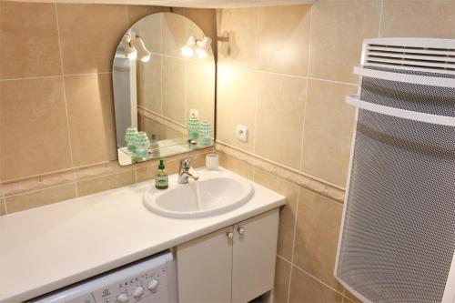 une salle de bain avec un lavabo et un miroir dans l'établissement Amirauté I 21 2pieces 4 personnes, à Saint-Cyprien