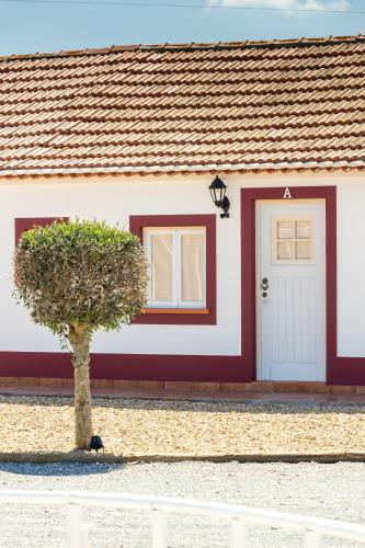a red and white house with a tree in front of it at Monte do Zeca in Zambujeira do Mar